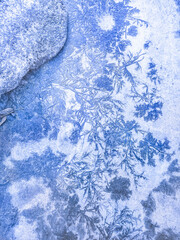 Frosty patterns on asphalt in the form of blue trees and ice flowers. Abstraction, winter background. Christmas Wallpaper