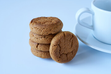 Crispy cookies with a white cup and saucer on a white background. The concept is breakfast.