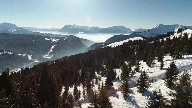Aerial drone footage of winter Alps landscape panorama. In picture you can see huge mountains covered with white cold snow and frosty wild forest in the valley.