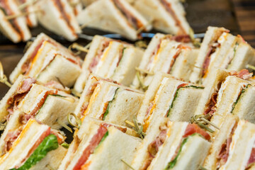Triangular appetizing sandwiches on the buffet table. Catering for events, holidays and business meetings. Close-up. Selective focus.