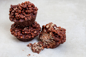 three puffed and crisp rice treats with milk chocolate made in tart tin on mottled grey with copy space