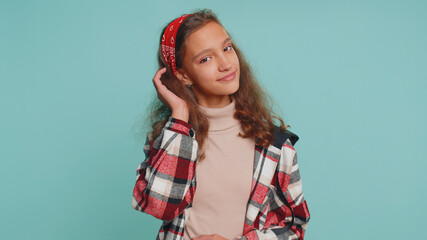 Cheerful lovely young teenager child girl kid in casual shirt smiling, looking at camera. Pretty preteen female children schoolgirl student isolated portrait alone on studio blue background. Childhood