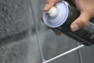 Closeup of man painting a fence with spray paint or aerosol paint