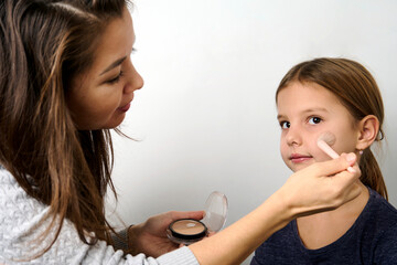 Little girl applying makeup, white background