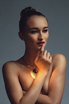Dark and moody photo of golden necklace on a model
