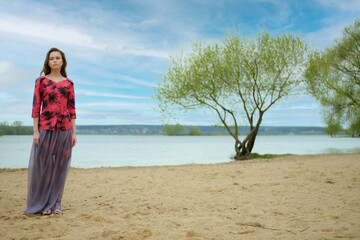 Lifestyle romantic portrait of a dreamy woman on the beach in a windy day