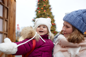 Mother and daughter are walking around the city on Christmas and New Year holidays. Portrait of happy mother and daughter having fun in the street