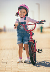 Girl, bike training and portrait, learning development and sports in street outdoor. Young child,...