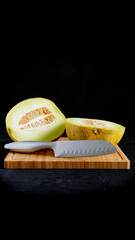 fresh cut melon on a wooden cutting board