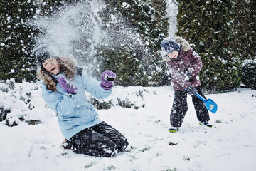 Happy Family, mother and son having fun outdoors in winter snowy nature background. Mom and kid playing snow ball at winter park outdoors