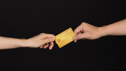 Two hands is hold gold credit card on black background..