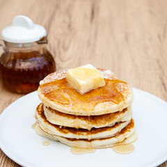 Stack of freshly made buttermilk pancakes with maple syrup and butter 