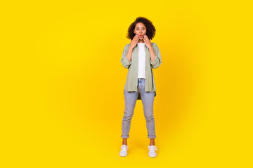 Full size photo of gorgeous young lady curly hair impressed unexpected news wear trendy khaki shirt isolated on yellow color background