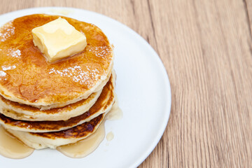 Stack of freshly made buttermilk pancakes with maple syrup and butter 