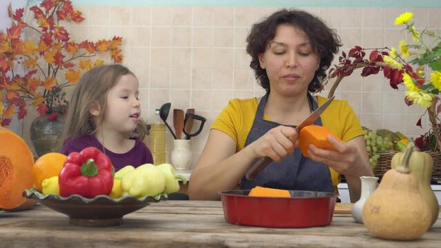 Cooking together for a festive Thanksgiving dinner. Female farmer mother and children cooks pumpkin pie for harvest festival