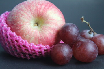 apples and grapes on a black background