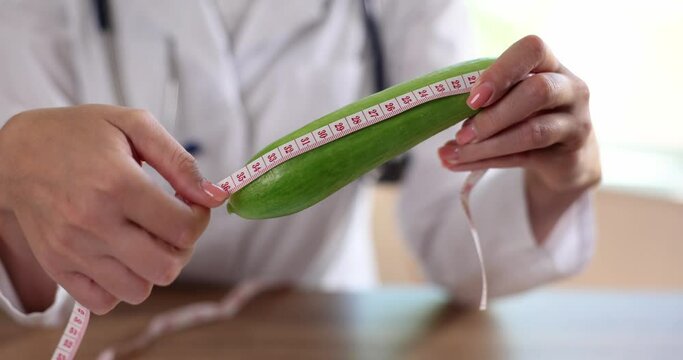 Urologist and andrologist measures cucumber with centimeter