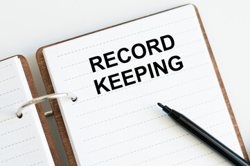 RECORD KEEPING text written on a notebook on the white background