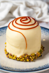 Caramel cake with pistachio on a white wooden background. Bakery desserts. close up