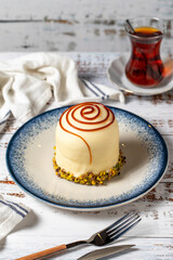 Caramel cake with pistachio on a white wooden background. patisserie desserts