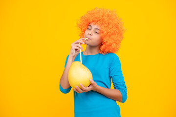 Teenager child girl hold citrus fruit pummelo or pomelo full of vitamin, isolated on yellow...