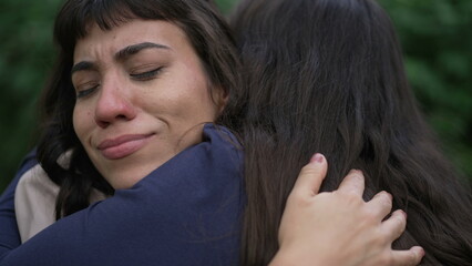 A sad hispanic woman having the support of empathic friend. Two latin women hugging each other in community