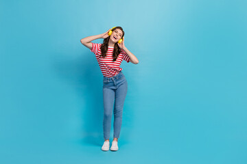 Full length photo of funny adorable girl dressed red t-shirt earphones singing having fun isolated blue color background