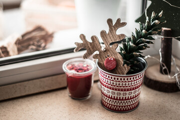 A wooden Christmas toy and a colored cone in a beautiful flowerpot.