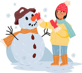 Child girl making a snowman, having fun at winter holidays and playing with snow.