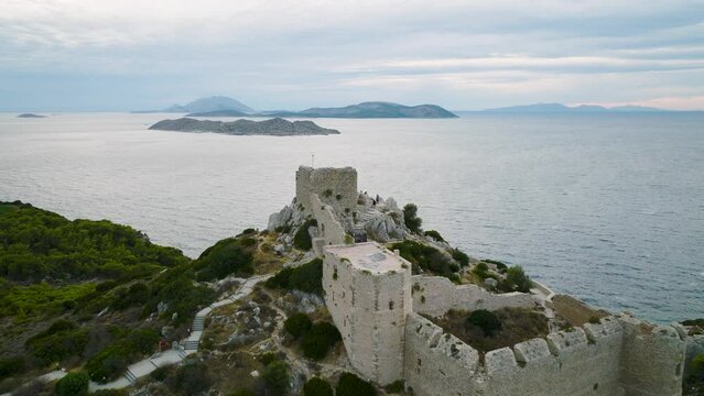 Drone pullback riser reveals medieval Kastellos castle overlooking Aegean Sea