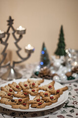 Cookies in the form of deer head with a red nose and a metal candlestick.