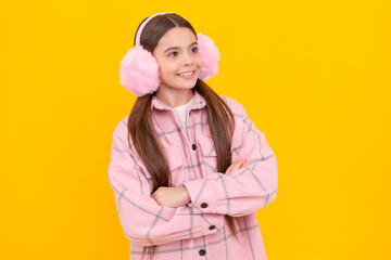 Confident kid in fur earmuffs and fashion winter wear smile keeping arms crossed, stylish