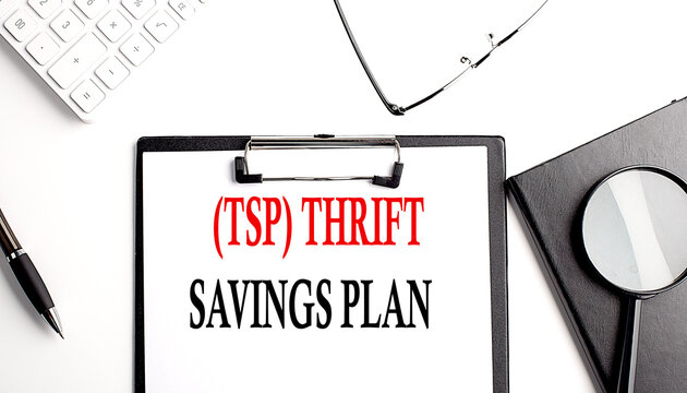 TSP THRIFT SAVINGS PLAN text written on paper clipboard with office tools