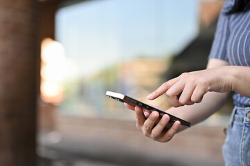close-up, Young Asian woman typing on her phone screen, using her smartphone