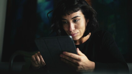 South American woman holding tablet device looking at content online2