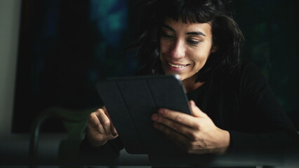 South American woman holding tablet device looking at content online2