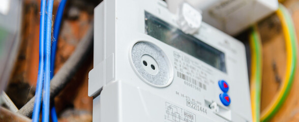 A domestic electric smart meter.Green LCD display.Concept for energy bills, price rise, inflation, cost of living and meter reading.Selective focus.Banner. - obrazy, fototapety, plakaty