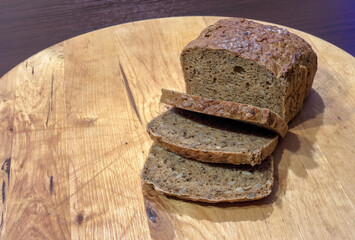 Dark wholemeal bread on a wooden board on the table