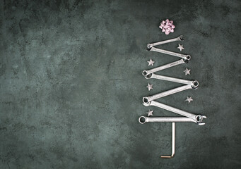 Christmas tree made with wrenches and stars, new year greeting card with repair tools, dark...