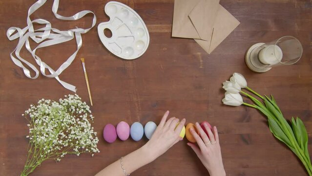 Top view of a table with items to create a composition for Easter. Women's hands arrange objects on the table. Church holiday-Easter