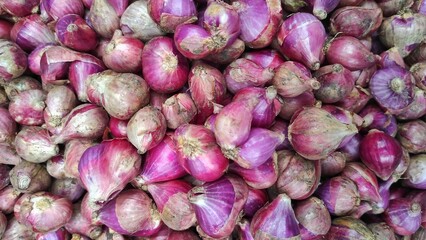 a pile of fresh red onion spice in the market stall