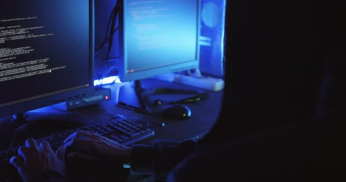 A male hacker is using a computer to hack data to demand ransom from victims.	
