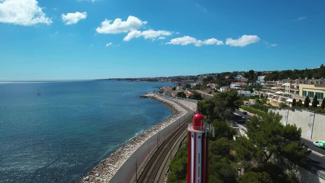Aerial view flying parallel to traffic on road N6, passing the Gibalta lighthouse, in Caxias, Portugal