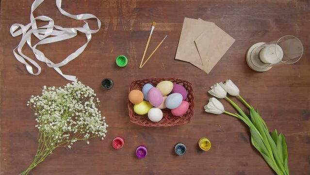 Top view of a table with items to create a composition for Easter. Women's hands arrange paints on the table. Church holiday-Easter