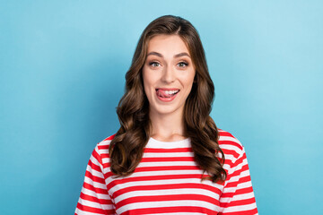 Photo of tricky cunning lady wear striped t-shirt smiling showing tongue isolated blue color background