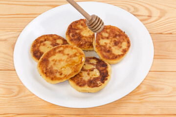 Cheese pancakes serving with honey on dish on rustic table