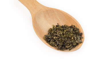 Dried green tea leaves in the wooden spoon