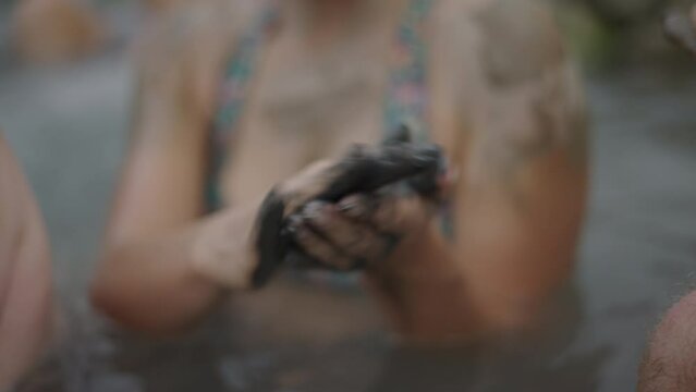 Hands of adolescent woman kneading mud in her hands