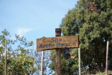 Segnaletica sentieri in legno, con scritto SITO ARCHEOLOGICO che significa archaeological site