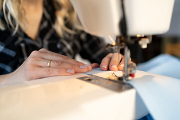 Close up of hands dressmaker scribbling fabric on sewing machine. tailoring at the factory.